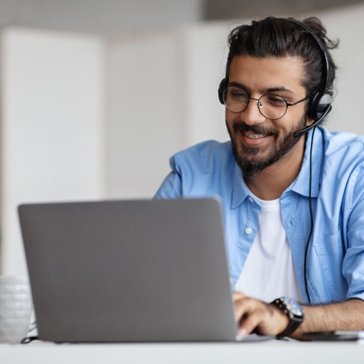 man working on laptop with headset