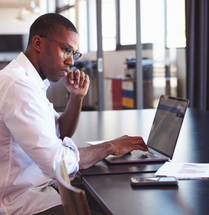 man seriously working on laptop